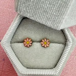 Close-up of Tiny Pink Daisy Stud Earrings showing pink enamel petals and gold center.